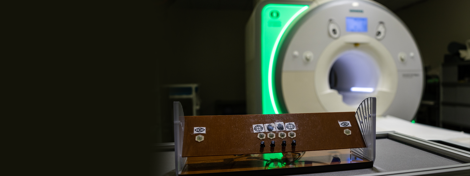 MRI machine with a green glow and UO logo. 