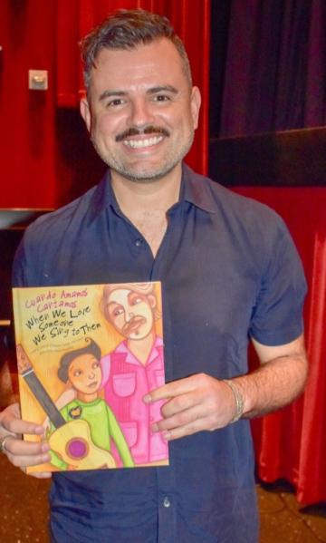 Ernesto Martínez holding his children’s book. 