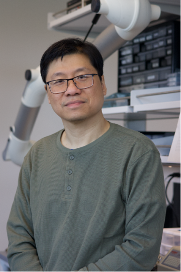 Portrait of Keat Ghee Ong subtly smiling in a lab setting.